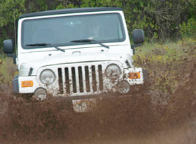 Jeep splashing through mud in Kauai